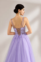 Set against a light backdrop, a woman wears a lavender tulle gown. It has thin straps, a sweetheart neckline with intricate lace embroidery on the bodice, and a flowing tulle skirt. The graceful design gives off a romantic and ethereal vibe, ideal for formal occasions such as proms or weddings.6