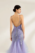 A woman stands against a light background, wearing a lavender mermaid gown. It has thin straps, a deep V - neckline, and is adorned with intricate silver bead patterns. The layered tulle skirt adds a romantic touch, perfect for formal events like galas or weddings, exuding elegance and charm.3
