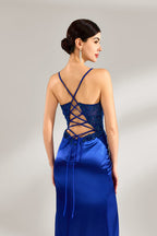 A woman stands against a light background, wearing a royal - blue satin gown. It features thin criss - cross straps at the back, intricate lace embroidery on the bodice, and a mermaid silhouette with a trailing skirt. The elegant design creates a glamorous look, perfect for formal events like galas or red - carpet occasions.6