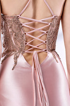 Set against a light backdrop, a woman dons a pink satin gown with a beaded, sheer bodice and a mermaid silhouette. The intricate bead patterns and flowing train add romance, combining sophistication and allure. Ideal for weddings or formal ceremonies, it exudes a regal aura.5