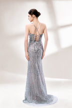 A woman stands against a light - hued background, wearing a light - grey, sheer gown adorned with intricate silver - toned bead patterns. It has thin straps, a deep V - neckline, and a mermaid silhouette. The detailed beadwork and sheer fabric create a glamorous look, perfect for proms or formal parties, radiating sophistication.2