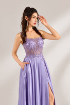 A woman with long, wavy dark hair and a confident pose wears a light - purple satin gown. It has thin straps, a sheer lace - detailed bodice, and a high side slit. Paired with silver - tone heels, the outfit radiates elegance, perfect for formal events like galas or evening receptions.5