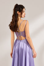 A woman with long, wavy dark hair and a confident pose wears a light - purple satin gown. It has thin straps, a sheer lace - detailed bodice, and a high side slit. Paired with silver - tone heels, the outfit radiates elegance, perfect for formal events like galas or evening receptions.6