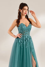 In front of a light - colored background, a woman is dressed in a teal tulle strapless gown. It has a sweetheart neckline, with the bodice adorned with delicate lace embroidery, and a high side slit. The voluminous tulle skirt, which has a slight shimmer, gives an elegant and romantic appearance, ideal for formal events such as proms or weddings.7