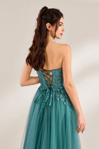 In front of a light - colored background, a woman is dressed in a teal tulle strapless gown. It has a sweetheart neckline, with the bodice adorned with delicate lace embroidery, and a high side slit. The voluminous tulle skirt, which has a slight shimmer, gives an elegant and romantic appearance, ideal for formal events such as proms or weddings.4