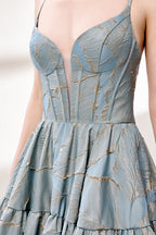 A woman stands against a light background, wearing a light - blue, tiered gown with gold - toned feather patterns. It has thin straps, a deep V - neckline, and a voluminous skirt. The unique jacquard design and elegant silhouette exude romance, perfect for formal events like garden parties or daytime weddings.6