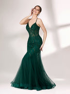 Illuminated softly, a woman captivates in a dark green evening gown. With sequin - tulle, mermaid silhouette, and sheer details, it creates a glamorous and sophisticated look for formal events.3
