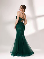 ：Illuminated softly, a woman captivates in a dark green evening gown. With sequin - tulle, mermaid silhouette, and sheer details, it creates a glamorous and sophisticated look for formal events.2