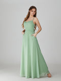 Sage green chiffon bridesmaid dress with cowl neckline, spaghetti straps, and pockets