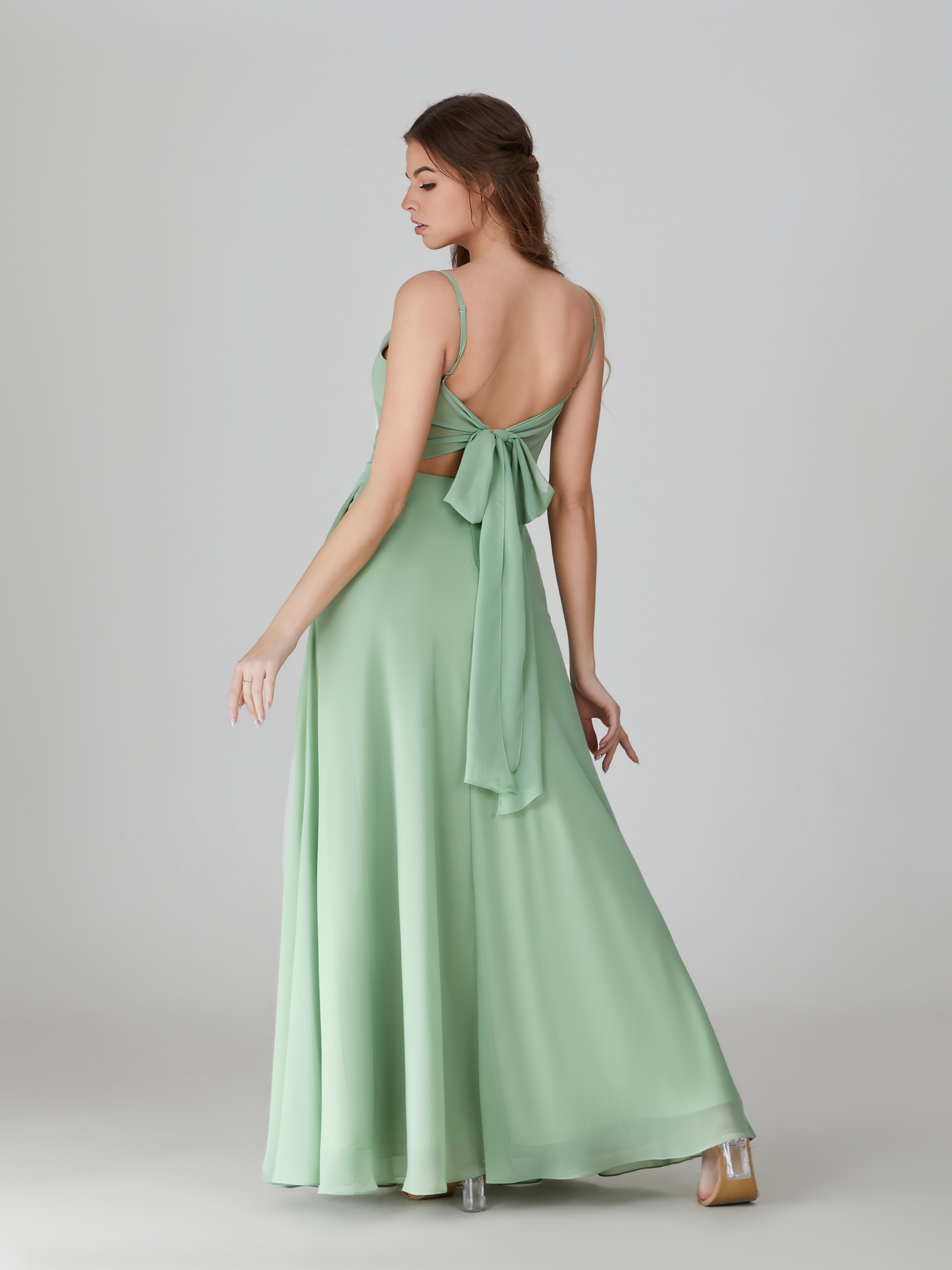 Sage green chiffon bridesmaid dress with cowl neckline, back bow, and pockets