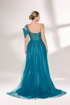 Against a light - hued backdrop, a woman dons a teal sequin gown with an one - shoulder design. It features a bow - detailed strap, a sheer waist panel, and a high side slit. The sparkling sequins and unique silhouette radiate glamour, perfect for formal dinners or galas.2