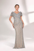A woman stands against a light background, wearing a silver - grey beaded gown. It features off - shoulder sleeves, a V - neckline, and a mermaid silhouette. The intricate bead patterns and sheer fabric exude elegance, perfect for formal galas or weddings, radiating timeless charm.1