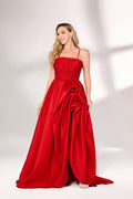 A woman with long, wavy blonde hair and a bright smile wears a vibrant red satin gown. It has thin spaghetti straps, a ruched bodice, and a voluminous, flowing skirt with a subtle train. Paired with simple, light - colored heels, the outfit exudes elegance, perfect for formal events like galas or weddings.01