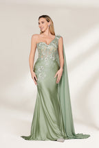 A woman stands against a light background, wearing a sage - green satin gown. It features a one - shoulder design with a flowing cape, floral lace embroidery on the bodice and skirt, and a mermaid silhouette. The elegant details and unique cape create a sophisticated look, perfect for formal events like galas or weddings.1