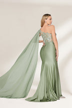 A woman stands against a light background, wearing a sage - green satin gown. It features a one - shoulder design with a flowing cape, floral lace embroidery on the bodice and skirt, and a mermaid silhouette. The elegant details and unique cape create a sophisticated look, perfect for formal events like galas or weddings.2