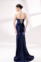 photograph, beautiful young woman, slim figure, long dark hair, fair skin, elegant navy blue strapless gown, fitted bodice with sparkling embellishments, high slit revealing leg, silver high heels, standing pose, white studio background, soft lighting, sophisticated, glamorous, fashion, evening wear, full body shot, elegant fashion photography, modern style, minimalistic setting, stylish, chic.33016-1-02