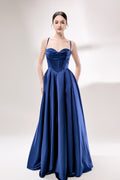 photo of a beautiful young woman, Asian descent, fair skin, long black hair in a low bun, wearing a stunning royal blue satin gown, corset-style top, full skirt, elegant and classy, standing against a plain white background, soft lighting, minimalistic setting, hands behind her back, confident pose, fashion photography, high-quality image, no watermarks.33119-01
