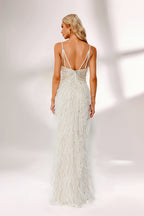 Illuminated by soft light, a woman captivates in a white feather - trimmed gown. It has thin straps, a V - neckline with intricate beadwork, and a high side slit. The glamorous design, with its feathery texture, creates an eye - catching and elegant look, perfect for formal events or red - carpet moments.2
