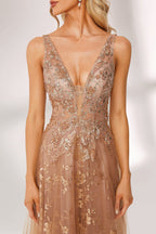 Set against a light backdrop, a woman is clad in a champagne - hued tulle gown. It boasts a deep V - neckline, long sheer sleeves adorned with lace embroidery, and a flowing tulle skirt featuring gold floral accents. The refined design exudes a romantic and luxurious charm, ideal for formal occasions such as proms or weddings.6