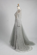 Silver long-sleeve mermaid gown, side view with tulle drape overskirt and beaded pattern