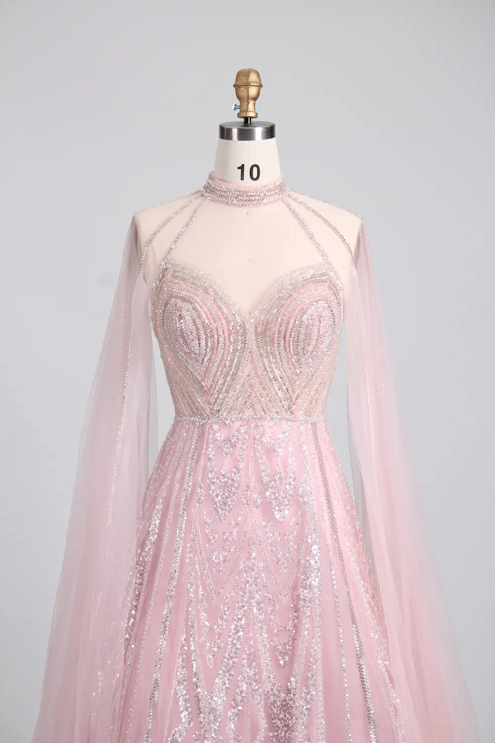 Blush pink high-neck crystal-beaded A-line gown with sheer cape sleeves
