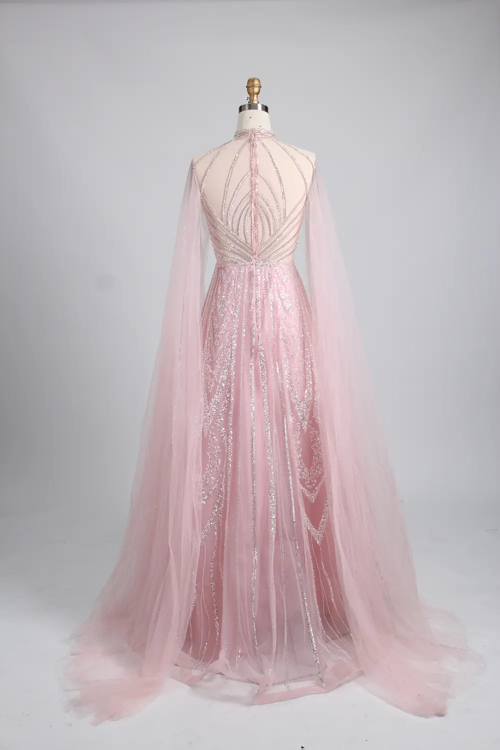 Blush pink A-line cape gown with open back beading and flowing tulle skirt