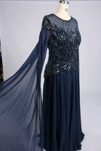 Navy A-line chiffon gown with ornate beaded bodice and flowing sheer cape sleeve