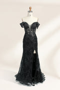 This photograph features a mannequin wearing an elegant, floor-length black lace gown. The gown has a sweetheart neckline, off-the-shoulder sleeves, and a high slit on one side, revealing a black thigh-high stocking. The intricate lace pattern is delicate and ornate, adding texture and visual interest. The mannequin stands against a plain, light beige background, emphasizing the dress's details. The number "2" is displayed on the mannequin's chest.01