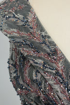 Close-up of dark gray beaded fabric on sleeveless V-neck evening dress bodice