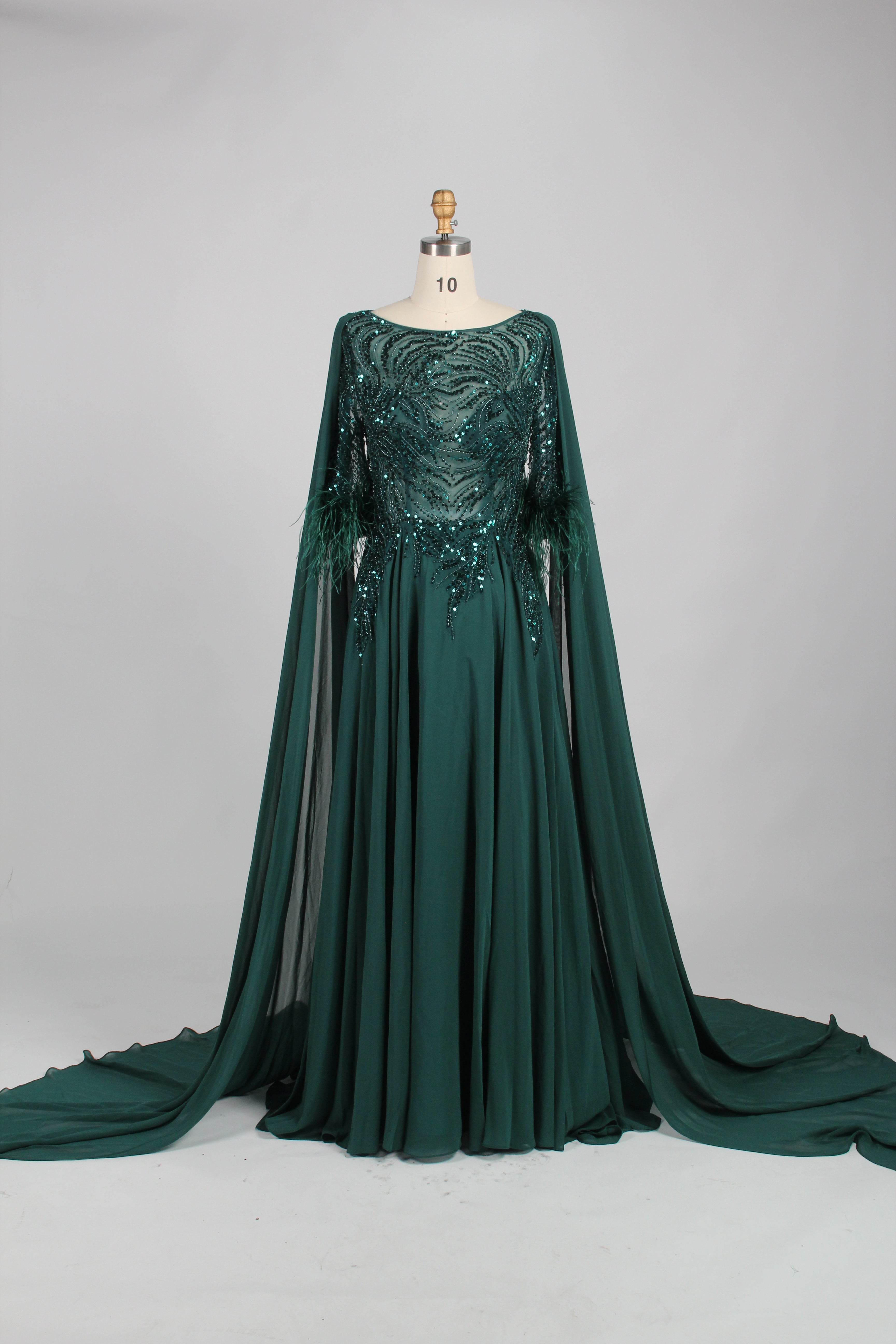 Green sequin evening dress with cape sleeves and feather-trim cuffs, flowing skirt