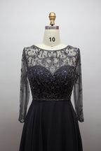 Black beaded bodice gown with sheer long sleeves and full pleated skirt
