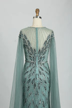 Teal beaded tulle cape mermaid dress shown from the back with long sleeves