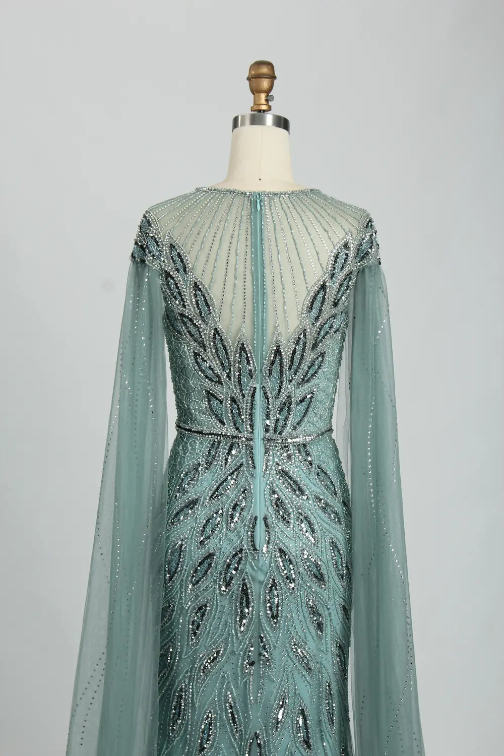 Teal beaded tulle cape mermaid dress shown from the back with long sleeves