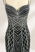 Set against a light background, a mannequin presents a black tulle gown with silver - toned beaded embellishments. Thin straps, a sweetheart neckline, and a mermaid - style skirt complete the look. The geometric bead patterns add a touch of glamour, ideal for proms or formal events where the beaded artistry stands out.5