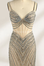 A mannequin numbered “6” displays a black tulle gown against a light backdrop. It features thin straps, a deep V - neckline, and a mermaid silhouette. The intricate silver bead patterns, sheer bodice with vertical accents, and high side slit add glamour, perfect for formal galas.6