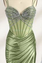 A mannequin presents a green satin gown with a bejeweled, sheer bodice against a light backdrop. It features thin straps, a sweetheart neckline, and a mermaid - shaped skirt. The sparkling embellishments and smooth fabric exude elegance, perfect for formal galas.6