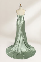 A mannequin showcases a strapless light - green satin gown against a soft, neutral backdrop. The dress features a twisted, criss - cross bodice with a subtle sheer panel and a mermaid silhouette, complete with a high side slit and a flowing train. The smooth, lustrous satin fabric and elegant design exude sophistication, perfect for formal galas or black - tie events.5