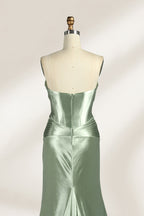 A mannequin showcases a strapless light - green satin gown against a soft, neutral backdrop. The dress features a twisted, criss - cross bodice with a subtle sheer panel and a mermaid silhouette, complete with a high side slit and a flowing train. The smooth, lustrous satin fabric and elegant design exude sophistication, perfect for formal galas or black - tie events.6