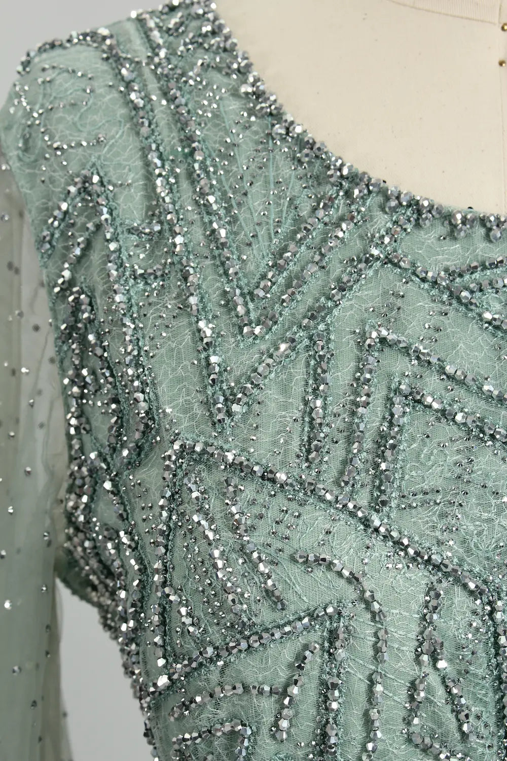 Teal beaded geometric embroidery on sheer sleeve bodice