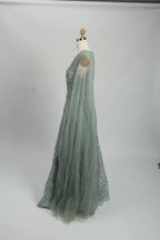 Teal beaded A-line evening dress with long sheer sleeves and cape-like overlay
