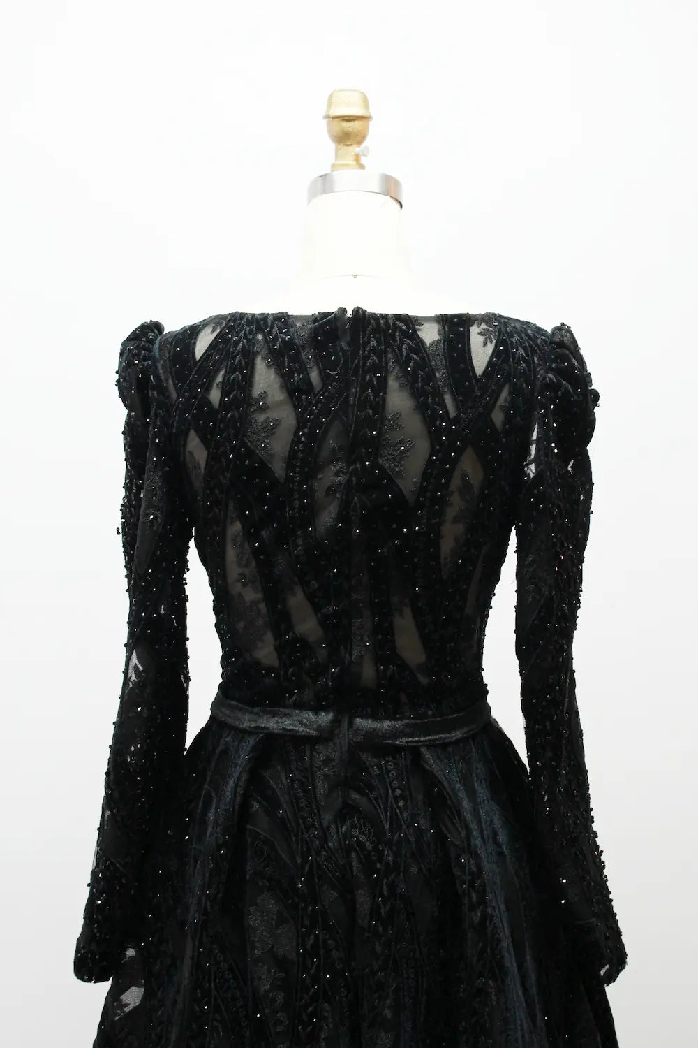 Black long-sleeve sequin back with sheer paneling and defined waist belt