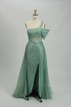 Against a light - hued backdrop, a woman dons a teal sequin gown with an one - shoulder design. It features a bow - detailed strap, a sheer waist panel, and a high side slit. The sparkling sequins and unique silhouette radiate glamour, perfect for formal dinners or galas.8