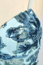 Set against a light background, a mannequin presents a light - blue tulle gown adorned with intricate floral sequin patterns. It has thin spaghetti straps, a sweetheart neckline, and a mermaid - shaped skirt with a high side slit. The shimmering sequins and delicate design create a glamorous look, ideal for proms or formal evening events.6