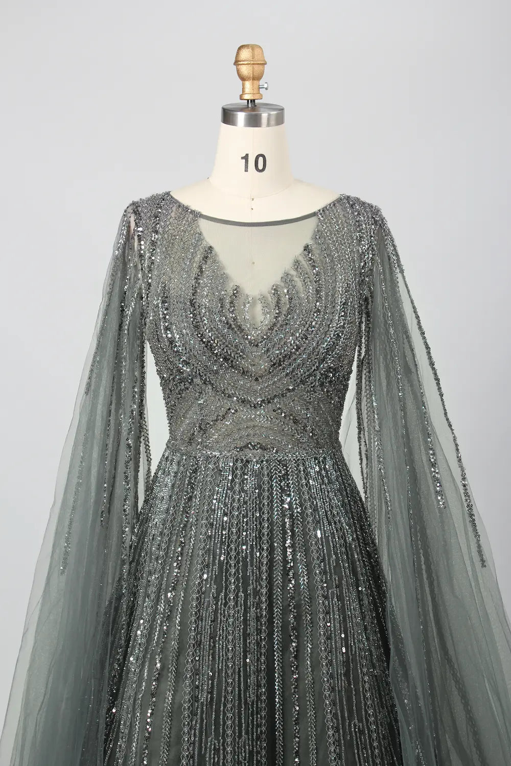 Beaded A-line gown with V neckline, sheer cape sleeves, and sparkling dark metallic beadwork