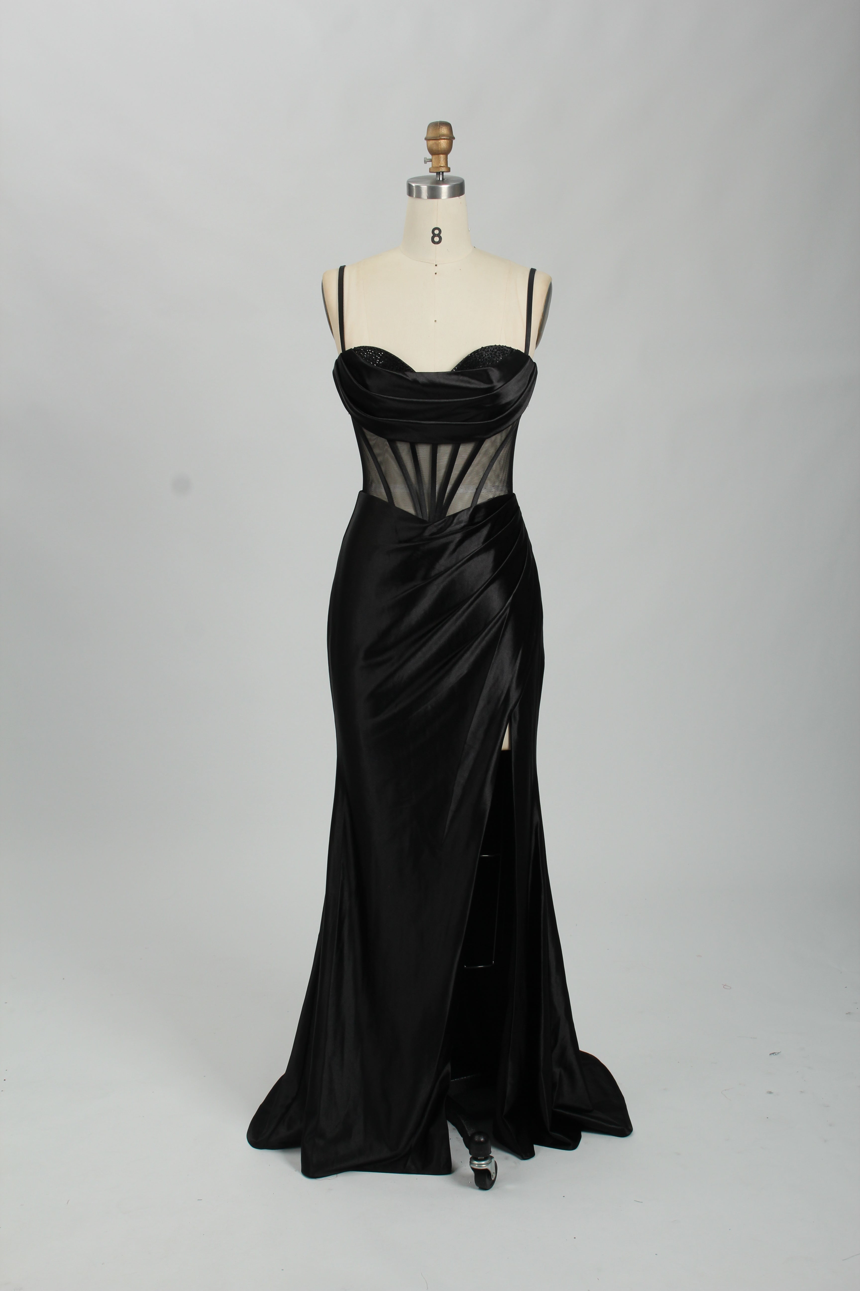 Black satin prom dress with sheer corset bodice, side slit & drape. Luxe, eye-catching design—perfect for bulk orders in premium formal collections.