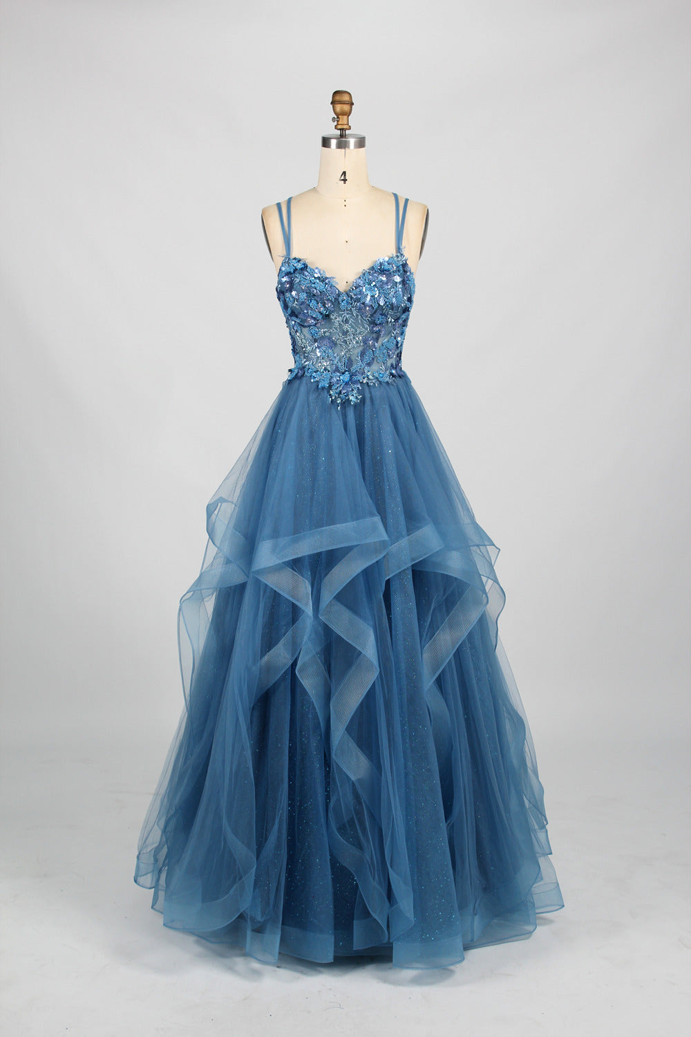 A mannequin displays a pink tulle gown. It features thin straps, a sweetheart neckline, intricate floral appliqués with sequins on the bodice, and a multi - layered, ruffled tulle skirt. The elegant design creates a romantic and glamorous look, perfect for formal events like proms or weddings.7
