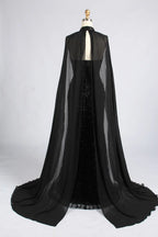 Back view of black beaded gown with sheer cape and long draped train