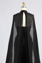 Black beaded gown back with sheer cape overlay and sparkly vertical embellishment