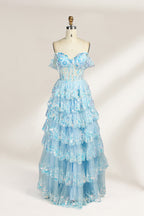 Photograph of a mannequin displaying a strapless, multi-layered, light blue tulle gown adorned with intricate floral embroidery. The gown has an off-shoulder neckline and a fitted bodice, cascading into voluminous, ruffled tiers. The background is plain white, highlighting the dress's delicate details. The mannequin is marked with the number "4" on its torso.1