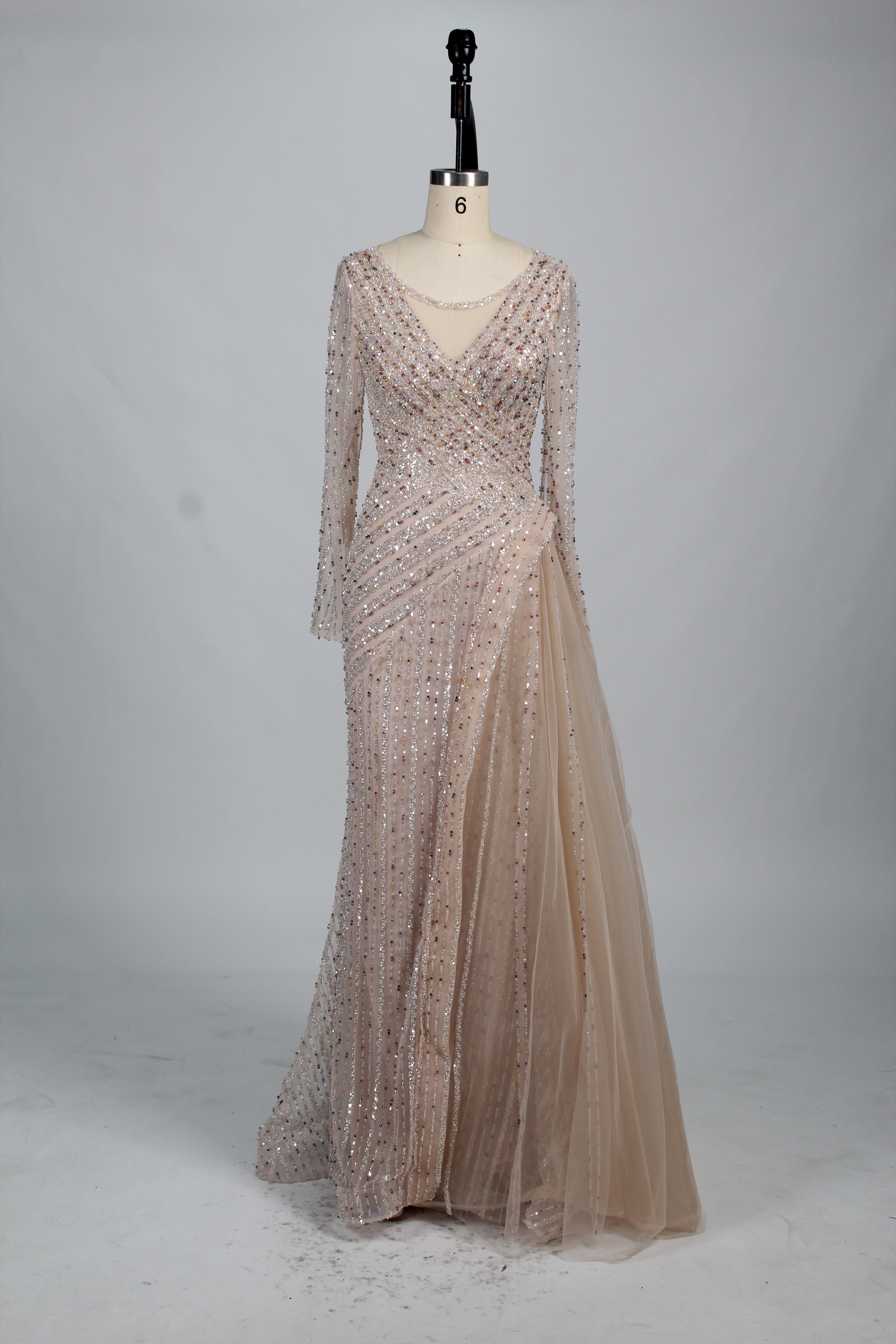Tea beaded long-sleeve evening dress on dress form with V-neck and sheer skirt